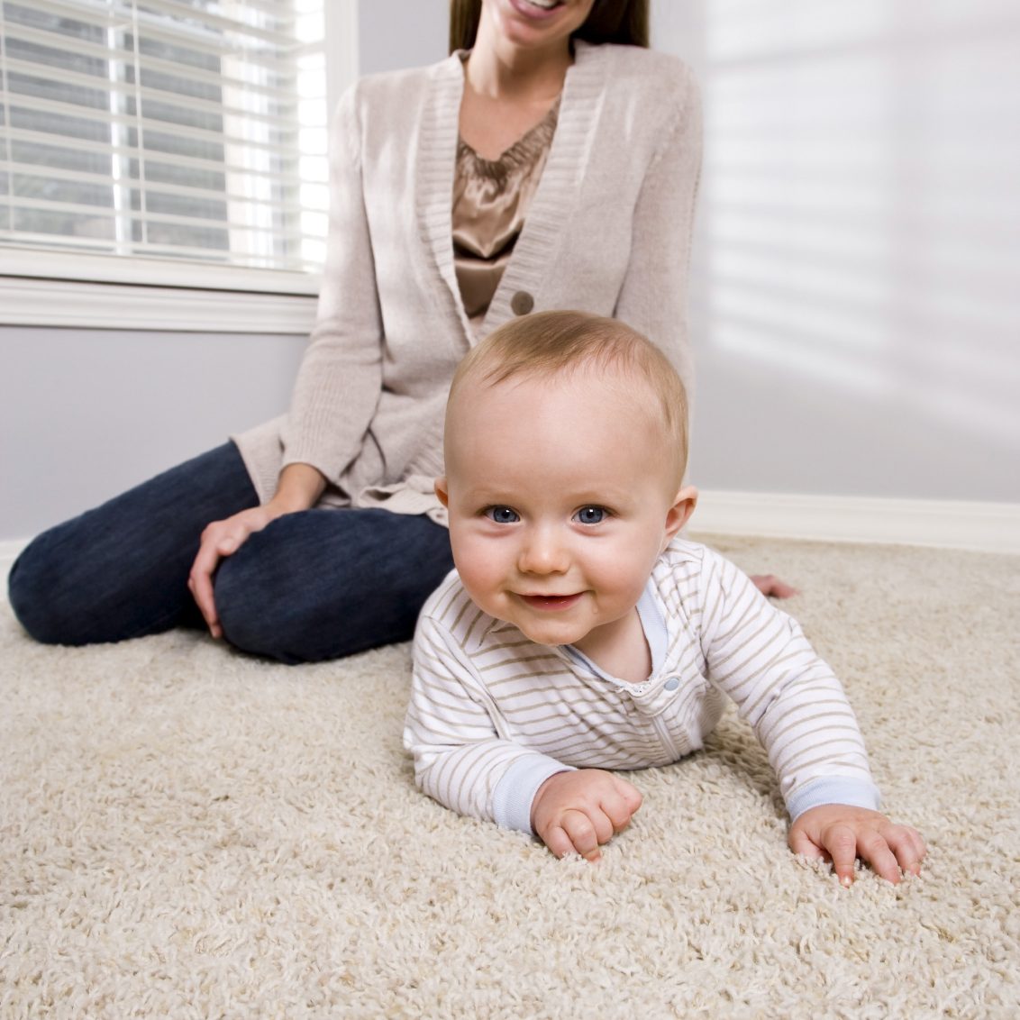 Clean carpets Dundee A smiling baby crawling on a carpet.
